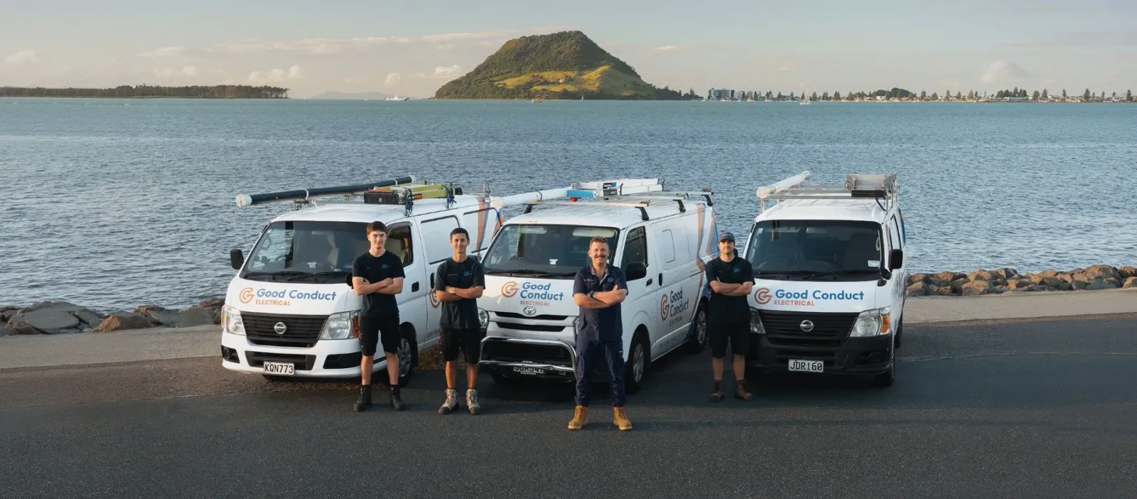 The Good Conduct Electrical team with their vans at Tauranga harbour